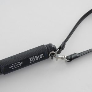 A black cell phone strap with a silver tag.