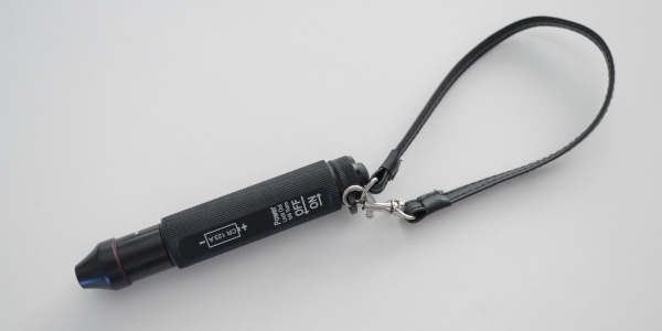 A black cell phone strap with a silver tag.