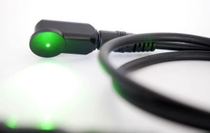 A green light is on the end of an electric cord.