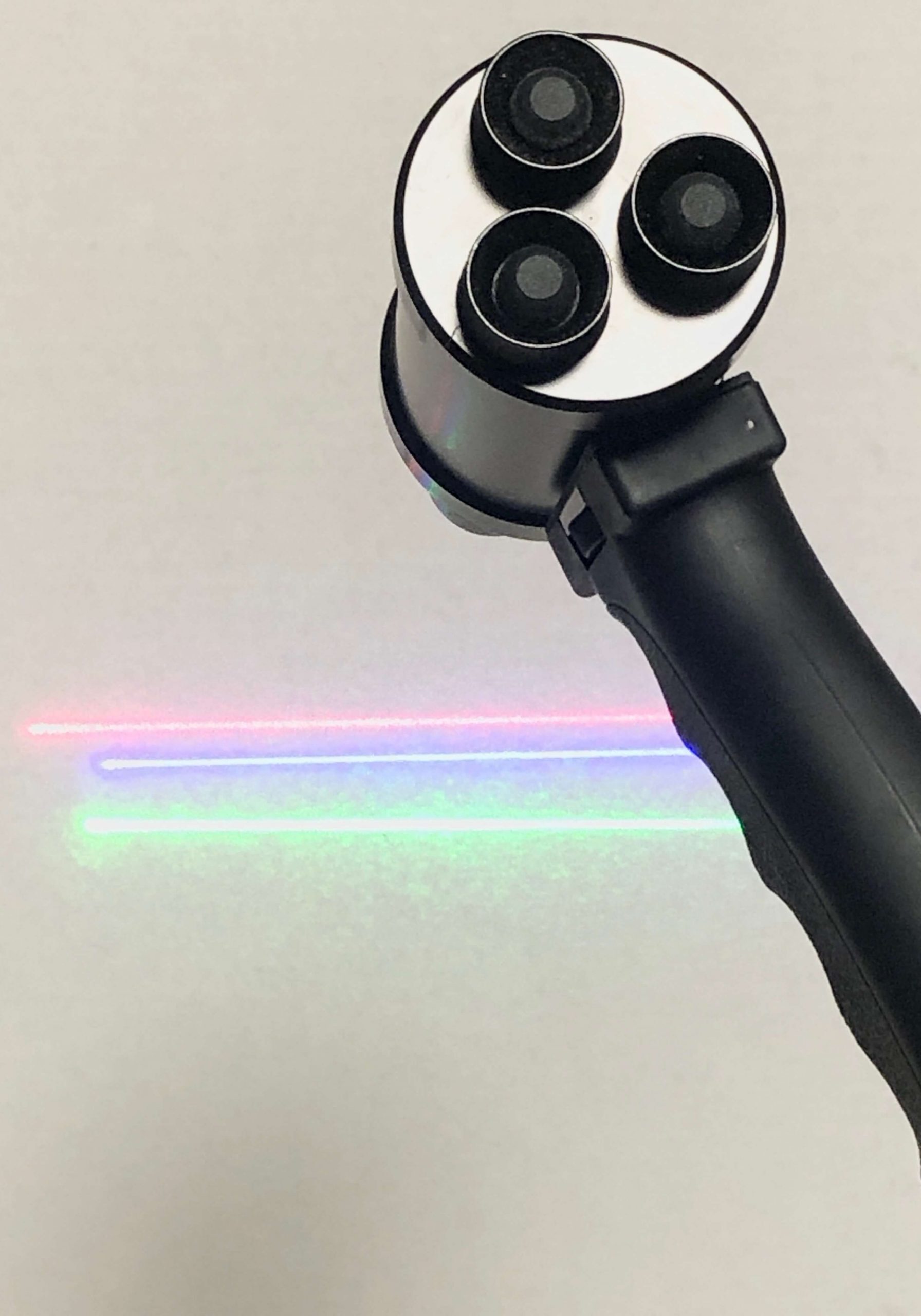 A black and silver camera with rainbow light coming from it.